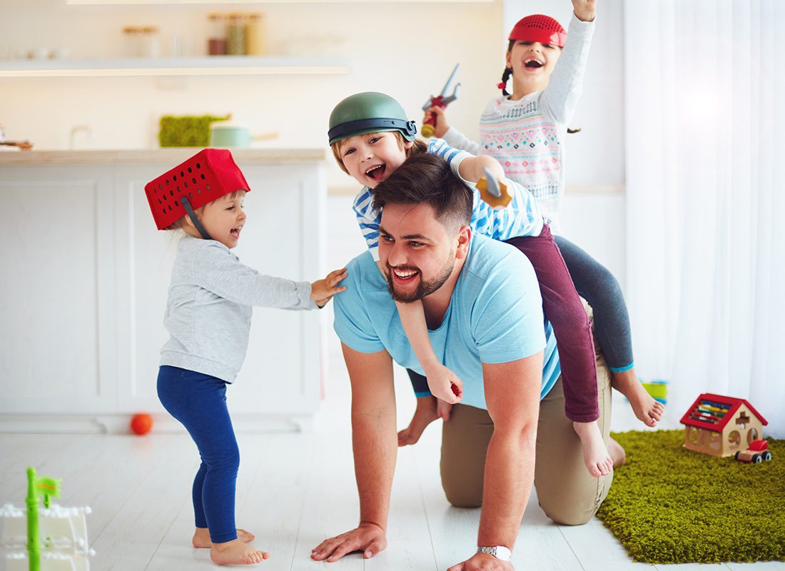 Personal Insurance - Happy Father Plays With His Three Children at Home